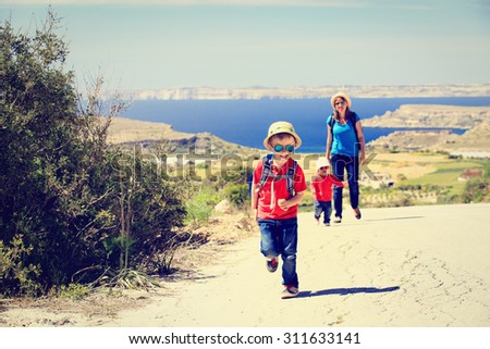 little boy with mother and sister travel walk on scenic road, family tourism