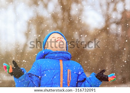 little boy enjoy first snow in winter nature, kids winter fun