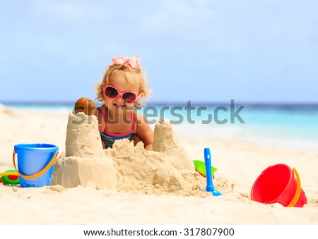 Similar – Image, Stock Photo Little girl building sand castle on beach