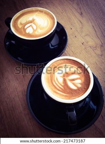 Two cups of latte or cappuccino on wooden desk , vintage filter effect