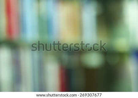 Blurred books on the shelf and the light from windows in public library. Blurred effect. Background for your pictures