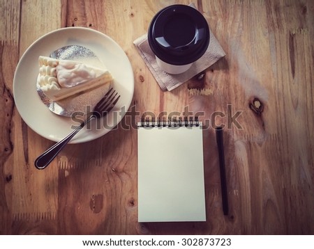 Top view of coffee and stationery mock up set with coffee, cake, notebook and pen