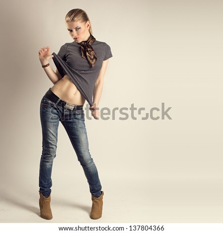Glamour stylish model wearing fashionable clothes and high heels. Pretty blue eyes young fashion girl with naked tummy.