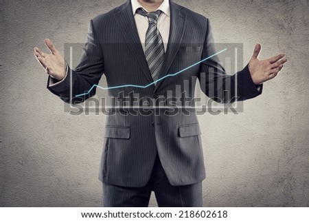 Portrait of young businessman showing flow chart of economic growth on the screen. Male entrepreneur with financial diagram posing in studio.