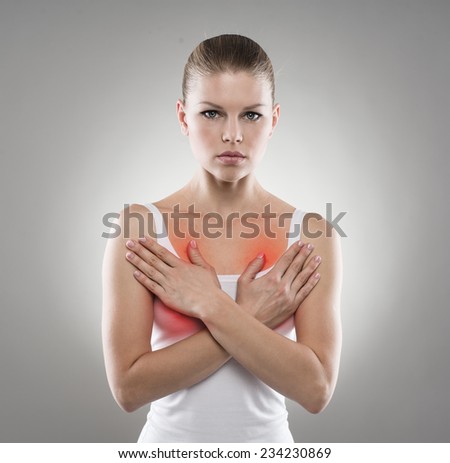 Young female examining her breast. Chest pain, therapy and care concept.