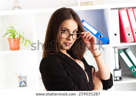 Close-up portrait of young woman entrepreneur standing in her office. Concept of leadership and confidence in business.