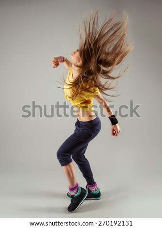 Portrait of young modern girl dancing hip hop in dance studio. Sport, health and leisure.