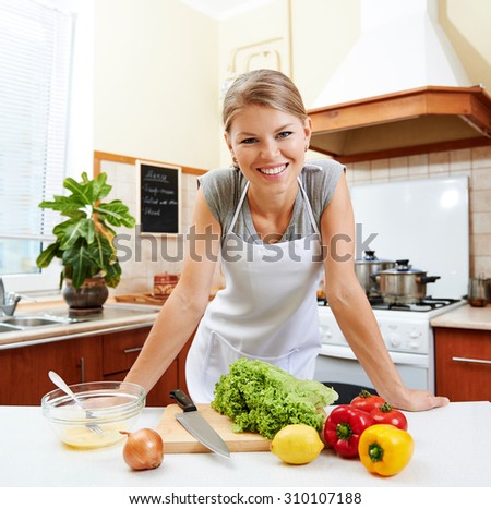 Happy smiling housewife working in kitchen preparing vitamin breakfast. Concept of diet, healthy nutrition and weight loss.