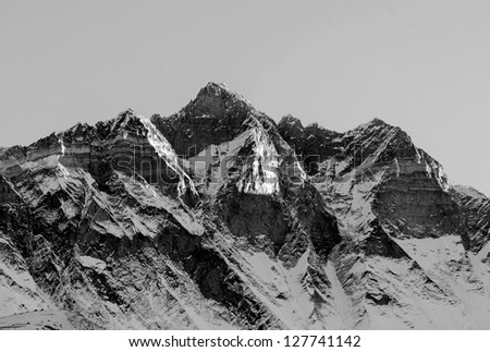 The first rays of the morning sun on the fourth in the world at the height of mount Lhotse (8516 m), view from the Chhukhung Ri  - Everest region, Nepal (black and white)