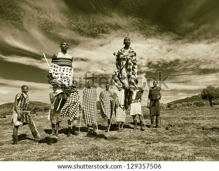 MASAI MARA, KENYA - DECEMBER 2: Masai warriors dancing traditional jumps as cultural ceremony. As well as women sing and dance. Masai Mara National Park, December 2, 2011 in Kenya (stylized retro)