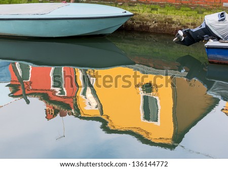 The boat and reflection in the water channel of the colorful house - Burano, Venice, Italy