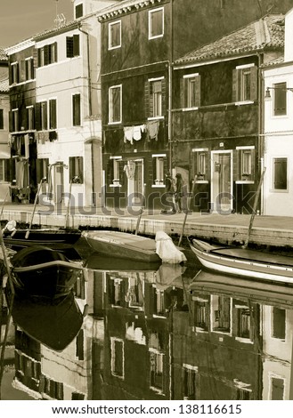 The reflection in the water channel of multi-colored houses - Burano, Venice, Italy (stylized retro)