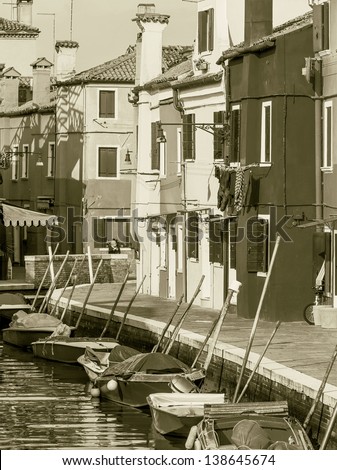 The multi-colored houses on the shore of a channel - Burano, Venice, Italy (stylized retro)