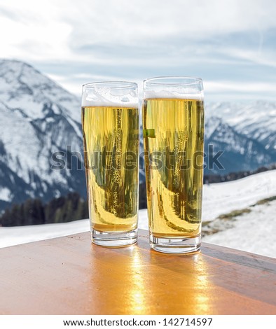 Glass of the fustrian beer against snow mountains a valley of the Zillertal - Mayrhofen, Austria