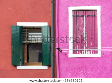 Closed window on the ancient magenta wall of the house and open window - Burano, Venice, Italy