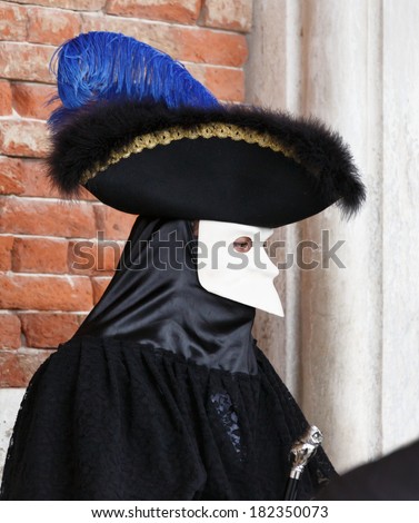 VENICE, ITALY - MAR 04, 2014: Unrecognizable persons wearing carnival costume (mask) in Saint Mark square in Venice, Italy. In 2014 the Carnevale di Venezia was held between 15 Feb - 04 Mar