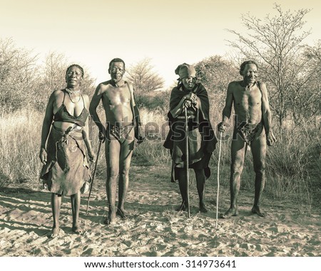 BUITEROS, NAMIBIA - JULY 17, 2014: Hunters Bushmen and their wives posing tourists. The Bushmens are members of various indigenous hunter-gatherer peoples of Southern Africa (stylized retro)