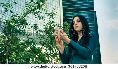 Impressive business woman holding the phone in front of the building business.