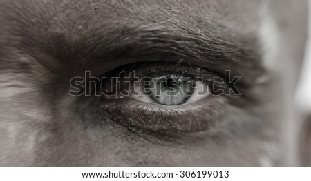 Macro man\'s eyes with pain and suffering in his eyes, the man in the mud.