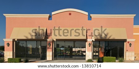 A brand  new, blank generic store front, in a contemporary strip mall.
