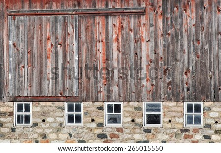 Old, weathered red barn with field stone foundation.