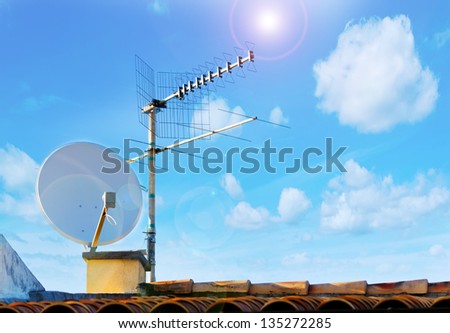 satellite dish and tv antenna on a sunny day