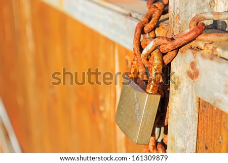 rusty padlock on a wooden gate