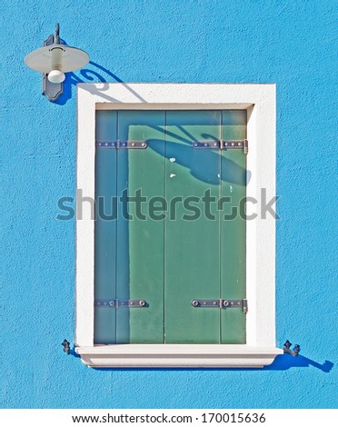 white door and window in a blue wall