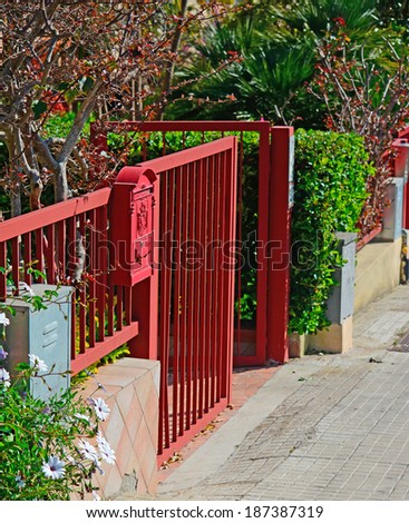 red gate with mail box on a sunny day
