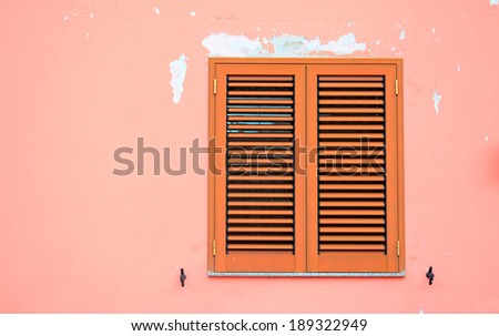 brown shutters in a pink wall