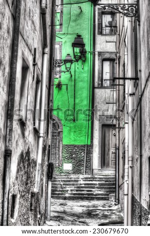 Narrow backstreet in Bosa old town. Processed for selective desaturation