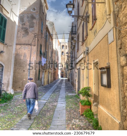 old man walking in a old street in Alghero old town. Processed for hdr tone mapping effect