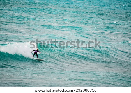 surfer riding a wave in the blue sea. Shot in Sardinia, Italy