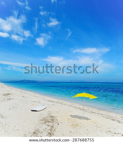 surfboard and beach umbrella on the sand