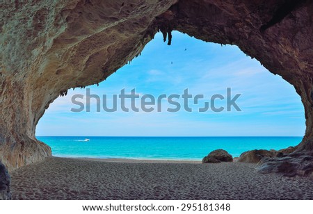motorboat passing by a big cave in Cala Luna, Sardinia