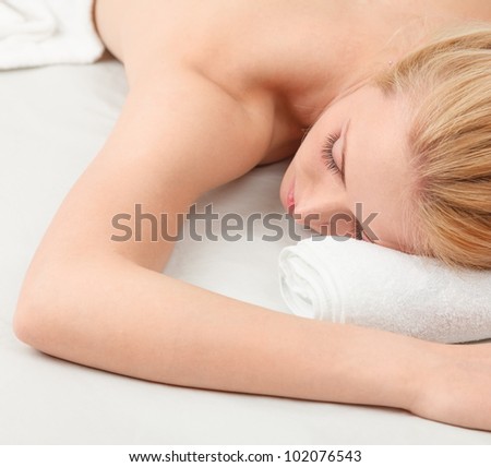 Sleeping young blonde woman lying down on white