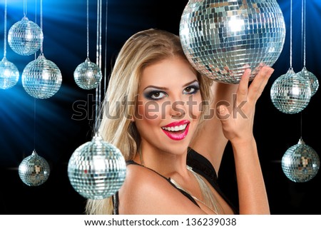 Young blonde woman dancing at night disco club