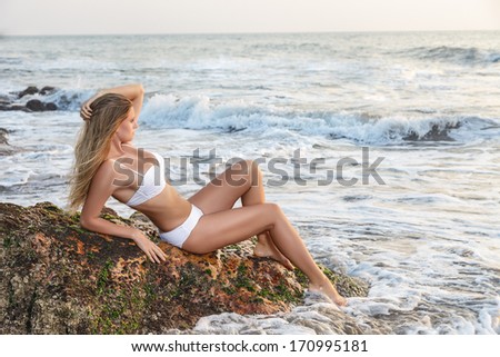 Young woman looking at sea. Sunset time outdoor portrait made in India, State Goa