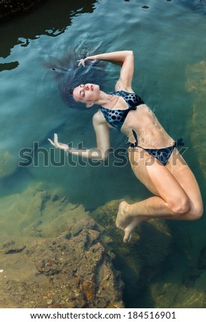 Young beautiful woman relaxing in water of tropical sea
