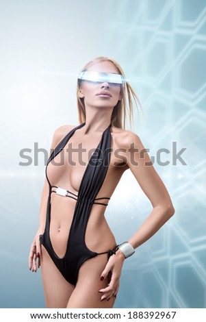 Young fashion futuristic woman posing with virtual reality cyberspace glasses