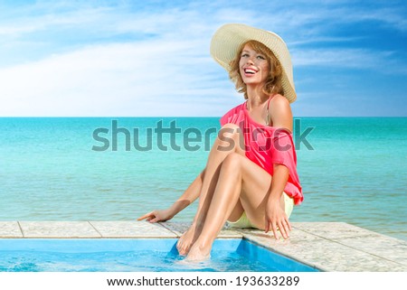 Young woman sun bathing in tropical spa resort swiming pool