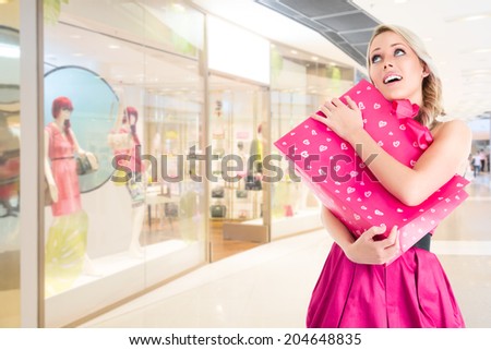 Young beautiful woman in pink mini dress at shopping mall