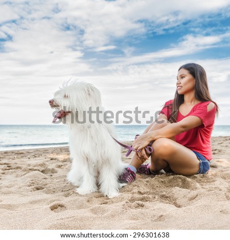 Young beautiful asian woman walking with dog near sea