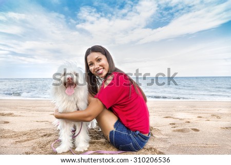 Young beautiful asian woman walking with dog near sea