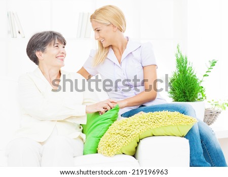 Mother and daughter talking in their living room.