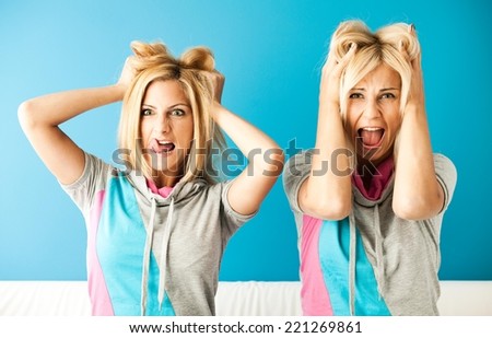Two desperate crazy women pulling their hair.