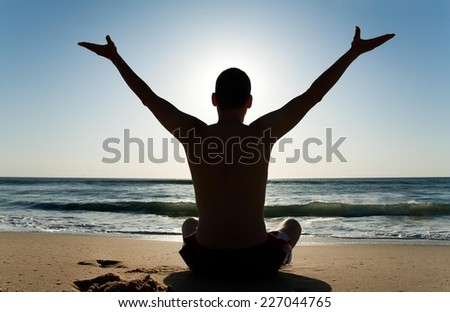 Young man rising his hands to the morning sky