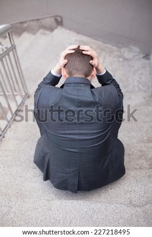 Young businessman holding his head in fear realizing mistake he made.