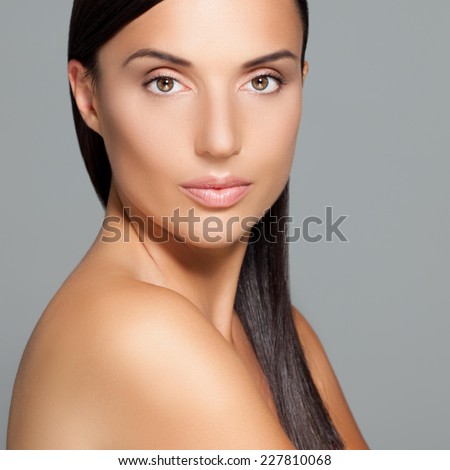 Beautiful woman with healthy silky hair looking at camera.