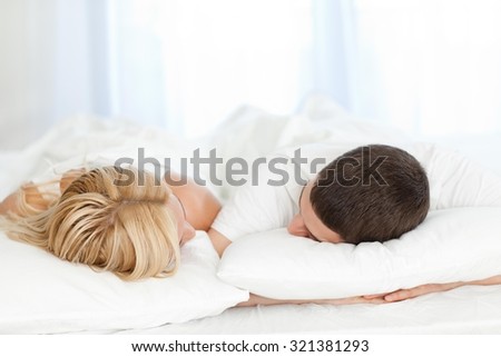 Couple sleeping in bed at home.